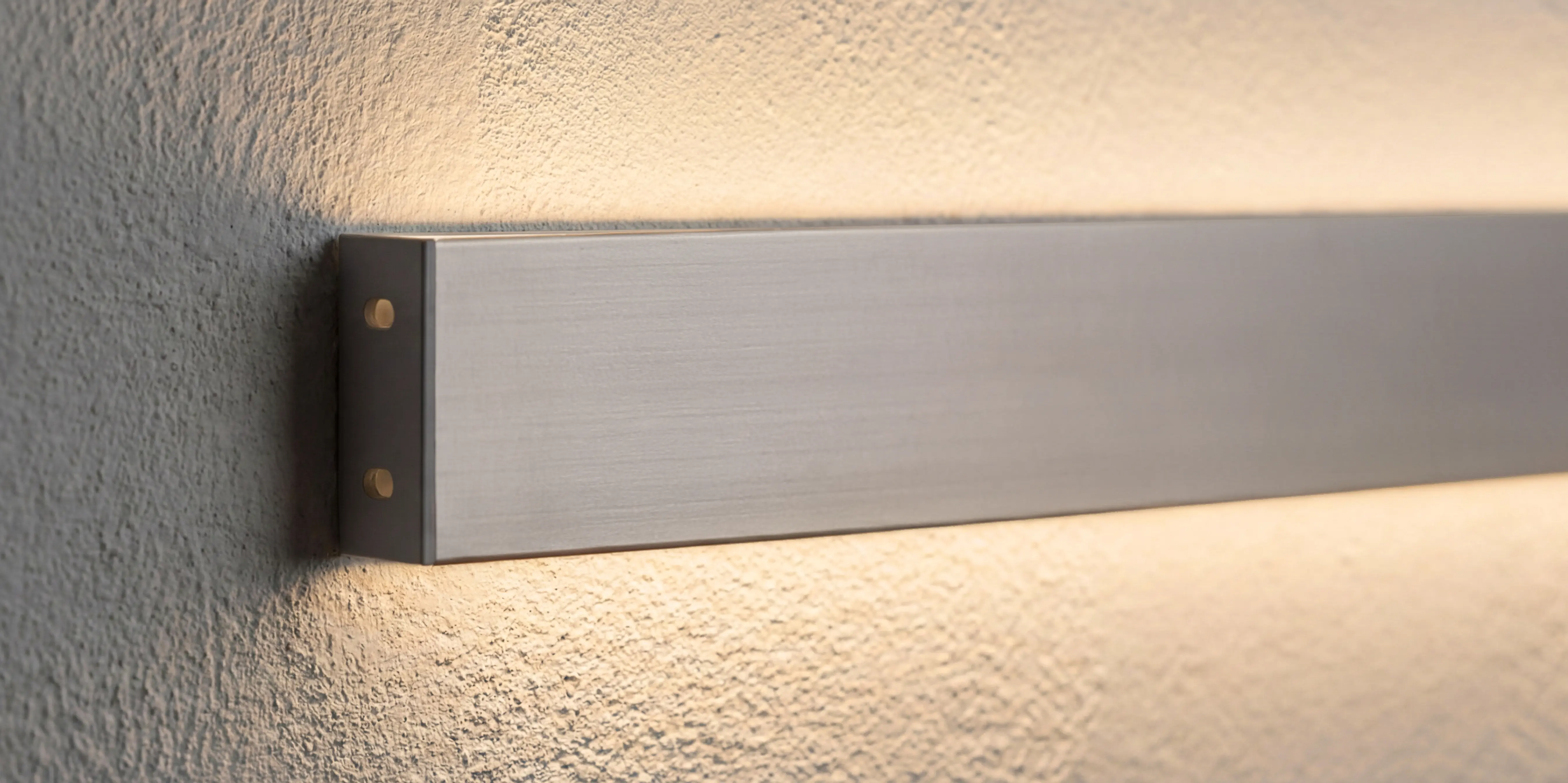 Schlankes Wandprofil mit LED-Licht, das nach oben und unten warmes Licht fuer einen modernen Effekt gibt